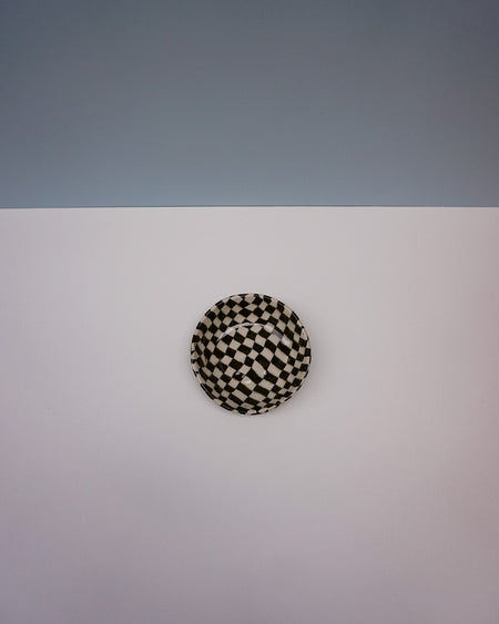 Round black and white checkered object on a light gray background. Fern Taylor | Nerikomi Dish | Shop Fodder