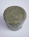 A cylindrical jar filled with a thick, textured gray-green cream or balm, photographed from a top-down angle on a plain white background. Brutes Ceramics | Hope Collection | Shop Fodder