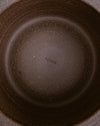 Close-up top-down view of the inside of a dark brown speckled ceramic pot or pan, showing the brand name 'scree' printed in the center. Scree Ceramics | Fodder | Hope Collection
