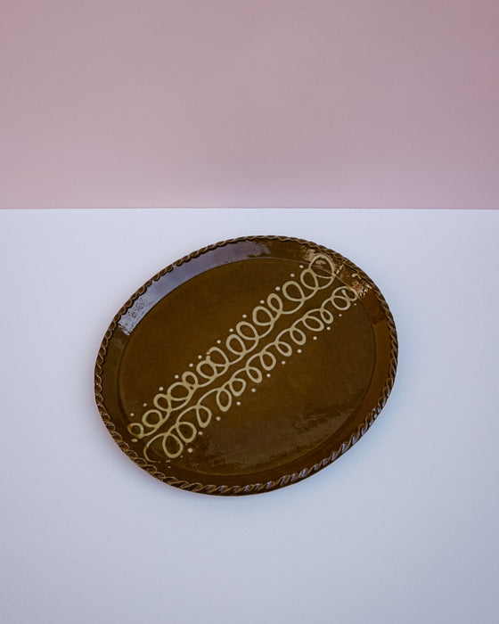 Close up of trailed cream slip pattern and pie crust rim