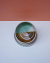 Ceramic dish with gradient colors on a white surface with a pink background. Liz Vidal Ceramics | Shop Fodder
