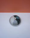 Ceramic jar with a lid on a white surface with an orange background. Liz Vidal Ceramics | Shop Fodder