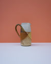 Ceramic pitcher with a geometric design on a peach background. Liz Vidal Ceramics | Shop Fodder
