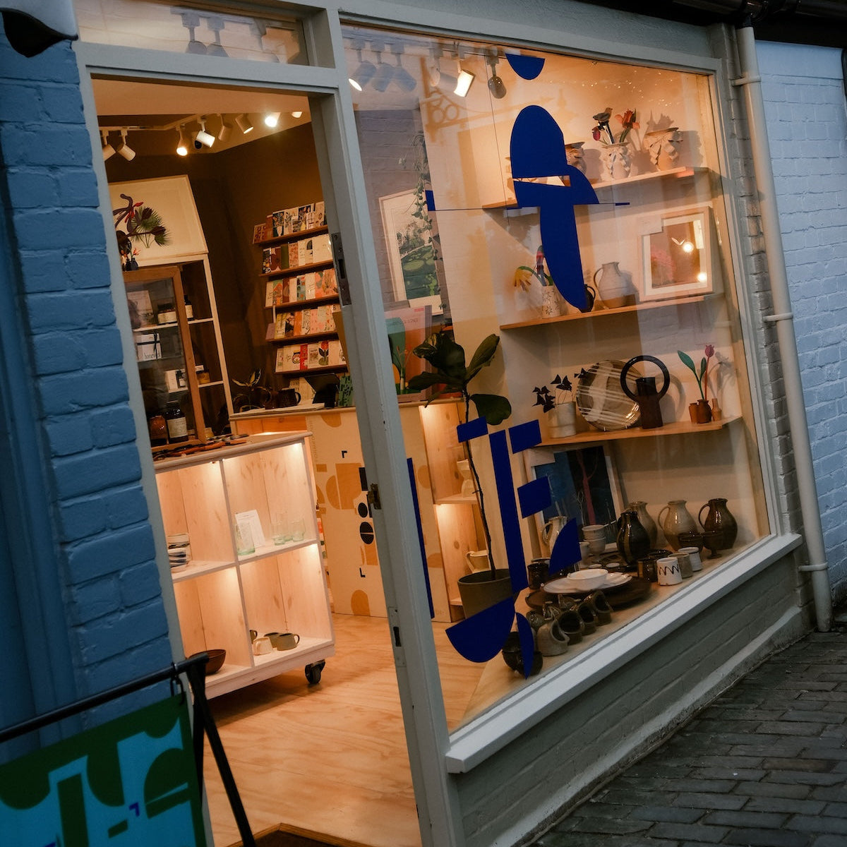 Storefront with a display of decorative items and a blue logo on the window. | Shop Fodder | Hampstead