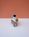 Ceramic vase with colorful abstract design on a white surface and peach background. Sophie Alda | Handmade Ceramics | Shop Fodder