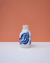 White bottle with blue wave design on a peach background. Sophie Alda | Handmade Ceramics | Shop Fodder