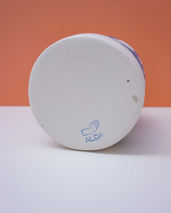 White container with blue lid on a white surface against an orange background. Sophie Alda | Handmade Ceramics | Shop Fodder