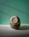Stack of ceramic bowls with floral patterns on a green and gray background. Sophie Alda | Handmade Ceramics | Shop Fodder