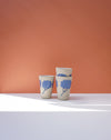 Three ceramic cups with blue floral designs on a peach background. Sophie Alda | Handmade Ceramics | Shop Fodder