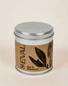 A St Eval Bay & Rosemary scented candle in a round silver metal tin with a brown kraft paper label featuring black botanical illustrations.