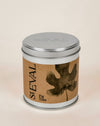 A cylindrical metal tin candle with a silver lid and a brown kraft paper label featuring a dark leaf graphic and the text 'st EVAL Fig Tree'. Fig Tree scented tin candle by St Eval - illustrated tin - Fodder