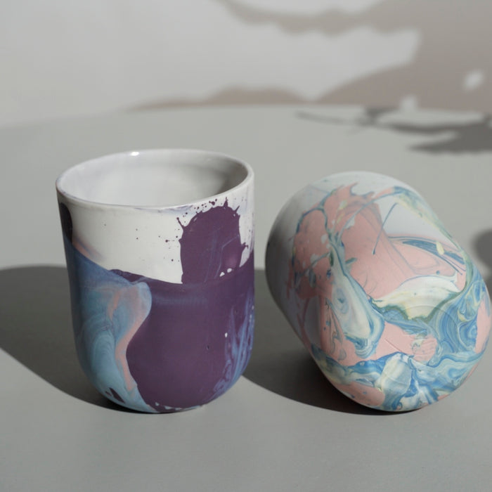 two planters on a table. one standing up and one on its side so you can see the base and the makers mark of JDP ceramics. 