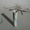a pale pastel marble effect bud vase handmade by JDP Ceramics in Porcelain sitting on a table and casting a long shadow. 