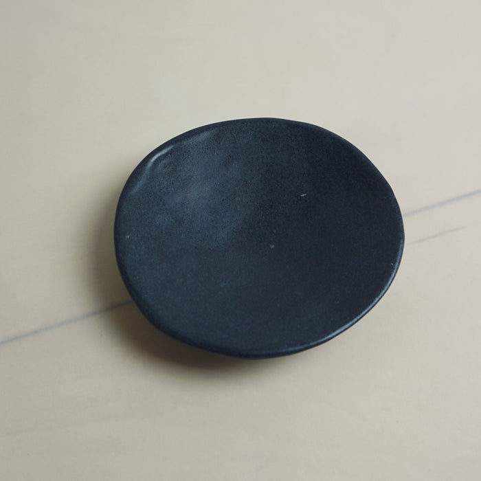 Black circular object on a light gray surface. Diddy Bowl | Jode Pankhurst | Shop Fodder