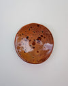 Round ceramic plate with brown speckled glaze on a white background. Diddy Bowl | Jode Pankhurst | Shop Fodder