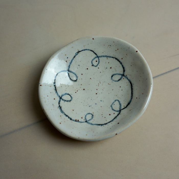 Small ceramic plate with blue decorative design on a beige surface. Diddy Bowl | Jode Pankhurst | Shop Fodder