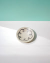 Round ceramic dish with decorative black pattern on a light green and white background. Diddy Bowl | Jode Pankhurst | Shop Fodder