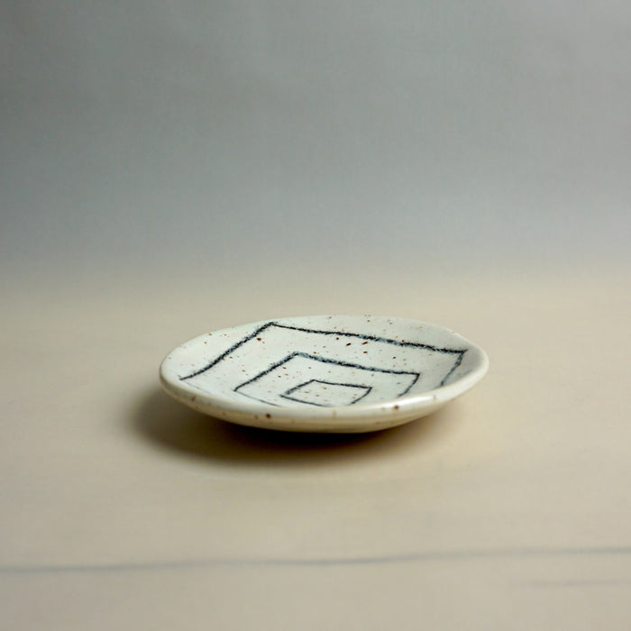 Small ceramic plate with black abstract design on a neutral background. Diddy Bowl | Jode Pankhurst | Shop Fodder