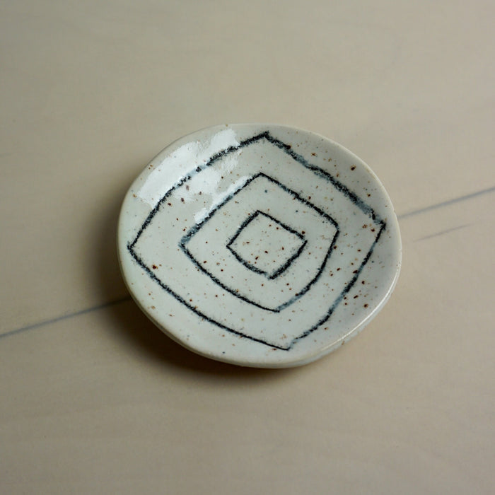 Ceramic dish with geometric pattern on a beige surface. Diddy Bowl | Jode Pankhurst | Shop Fodder