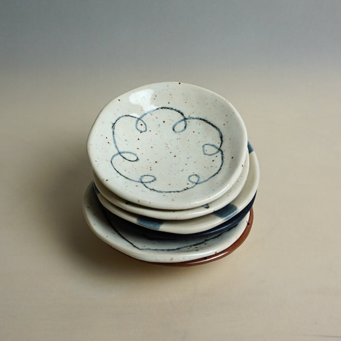 Stack of ceramic plates with blue decorative patterns on a neutral background. Diddy Bowl | Jode Pankhurst | Shop Fodder