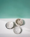 Three ceramic dishes with abstract patterns on a white surface and teal background. Diddy Bowl | Jode Pankhurst | Shop Fodder
