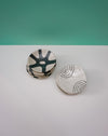 Set of ceramic coasters with abstract designs on a white surface and teal background. Diddy Bowl | Jode Pankhurst | Shop Fodder