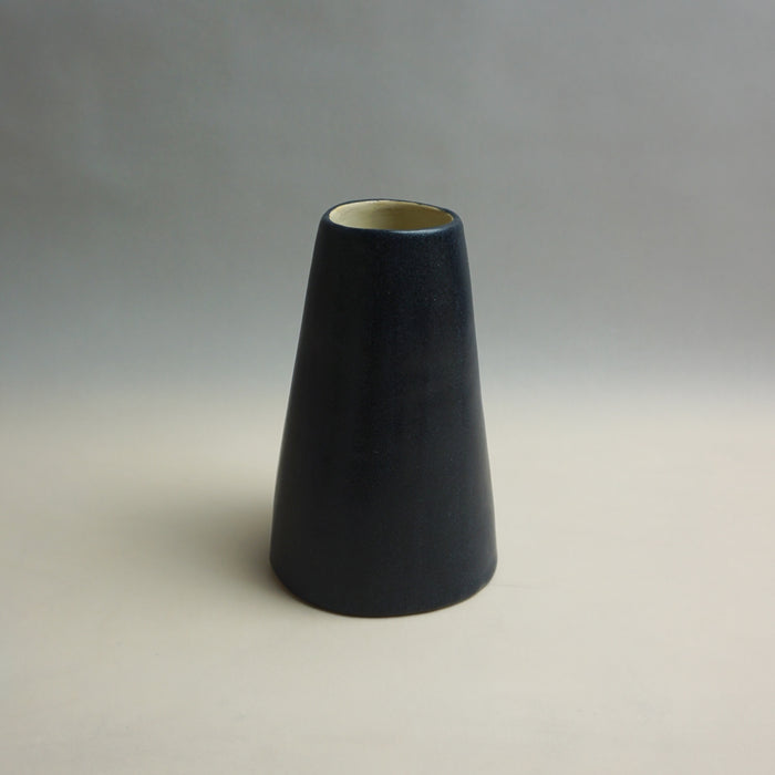 Black cone-shaped vase on a gray background. Fluted Ceramic Vase | Jode Pankhurst | Shop Fodder