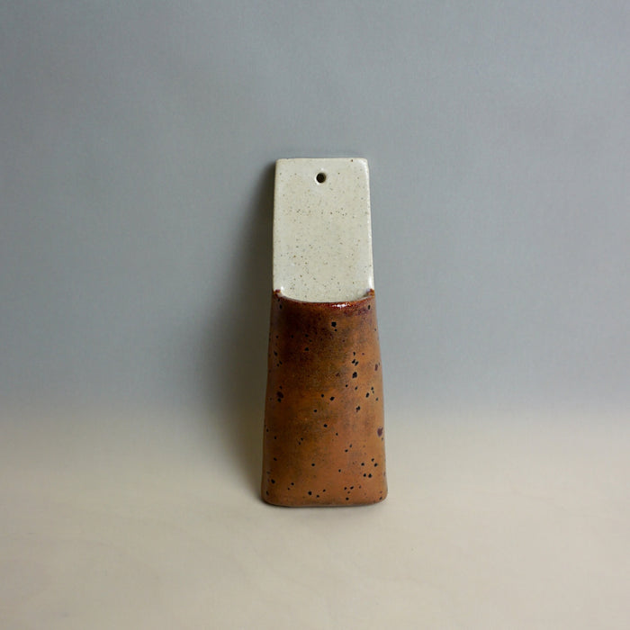 Ceramic vase with a two-tone design on a plain background. Pocket Wall | Jode Pankhurst | Shop Fodder