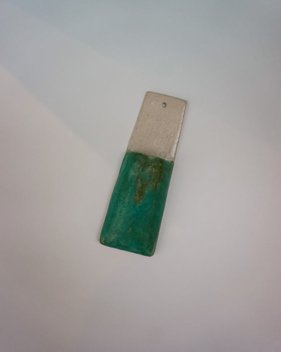 Rectangular object with green top and silver bottom on a light gray background | Jode Pankhurst
