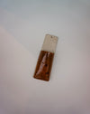 Rectangular object with a metallic top and brown bottom on a light gray background | Jode Pankhurst