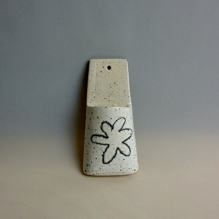 Speckled ceramic vase with a black flower design on a gray background. Pocket Wall | Jode Pankhurst | Shop Fodder