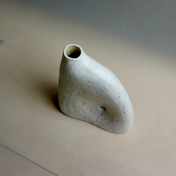 Small ceramic vase on a beige surface with a blurred background. Samara Collection | Jode Pankhurst | Shop Fodder