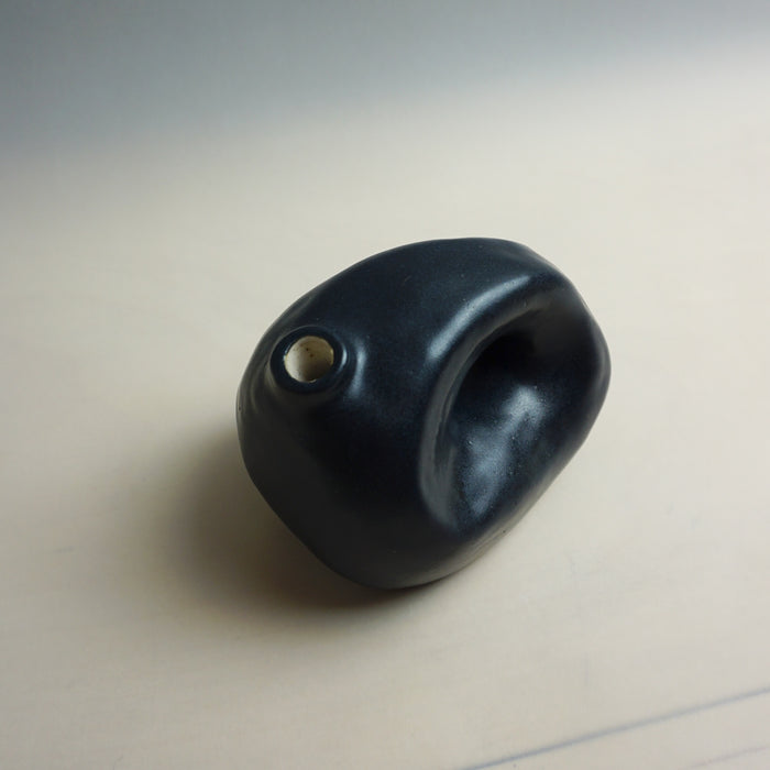 Black stone-like object on a light beige background. Samara Collection | Jode Pankhurst | Shop Fodder