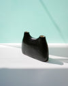 Black ceramic vase on a white surface with a light blue background | Jode Pankhurst