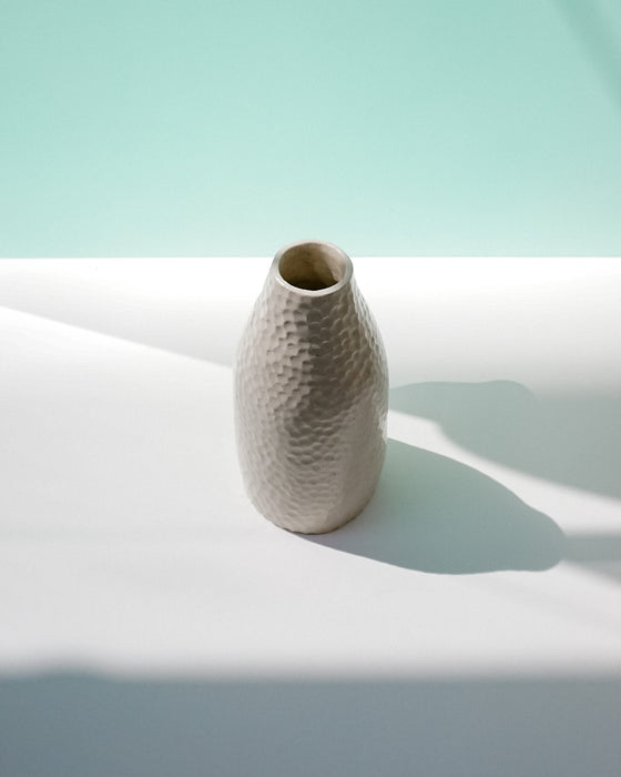 Textured ceramic vase on a light surface with a soft green background | Jode Pankhurst