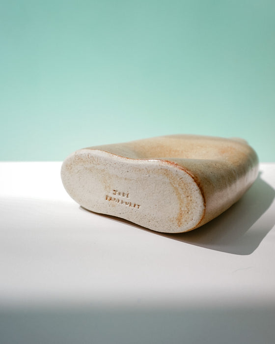 Wooden shoe last on a white surface with a light green background | Jode Pankhurst