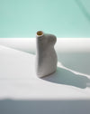 White ceramic vase on a light blue surface with a soft focus background | Jode Pankhurst