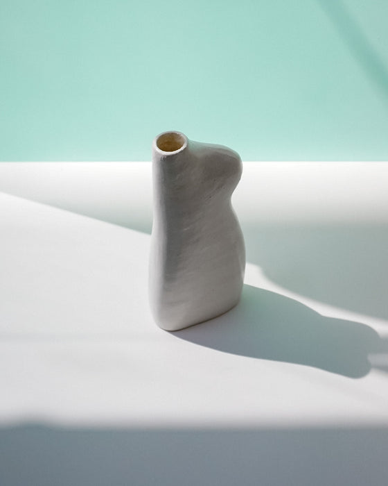 White ceramic vase on a light blue surface with a soft focus background | Jode Pankhurst