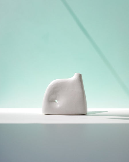 White ceramic sculpture on a light gray surface with a light blue gradient background | Jode Pankhurst