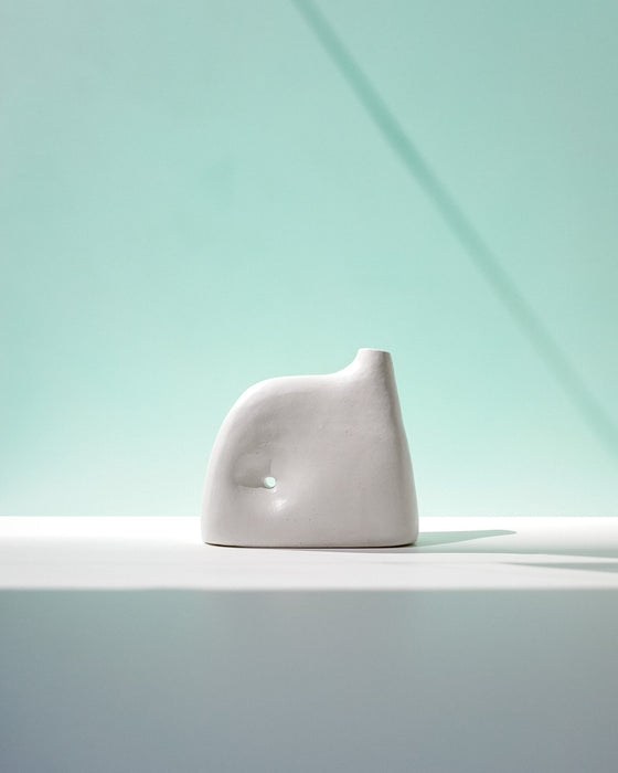 White ceramic sculpture on a light gray surface with a light blue gradient background | Jode Pankhurst