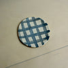 Round ceramic coaster with blue and white checkered pattern on a beige surface. Trinket Dish | Jode Pankhurst | Shop Fodder