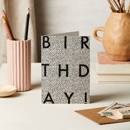 a birthday card with block text and an animal polka dot print. 