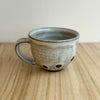 Ceramic mug with speckled design on a wooden surface. Lily Pearmain Ceramics | Shop Fodder