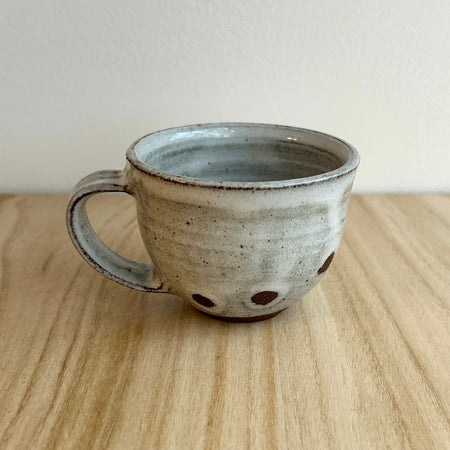 Ceramic mug with speckled design on a wooden surface. Lily Pearmain Ceramics | Shop Fodder