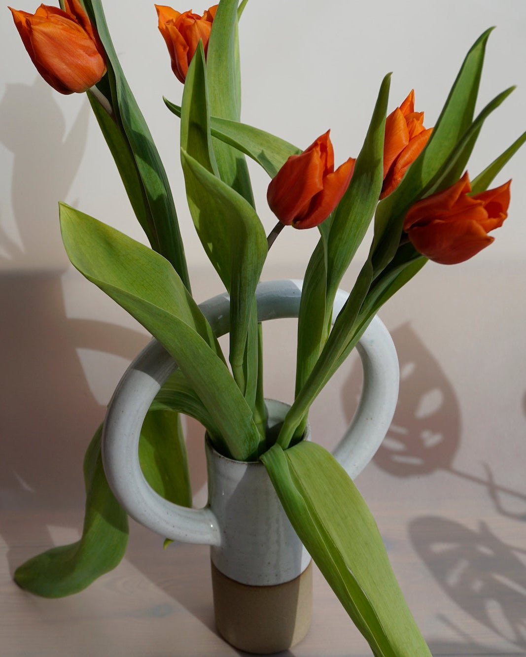 Lily Pearmain Ceramics | Doughnut Vase | Shop Fodder. A straight vase with an oversized round handle at the top. and a bunch or red tulips