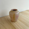 Small ceramic vase with speckled glaze on a wooden surface. Mae Ceramics | Shop Fodder