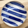 Ceramic plate with blue and white stripes on a wooden surface. Mae Ceramics | Shop Fodder