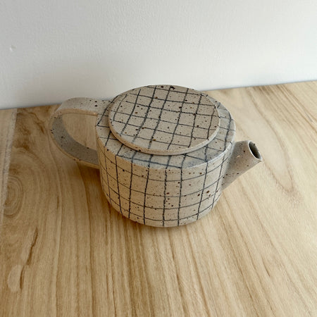 Ceramic teapot with grid pattern on lid and body, placed on a wooden surface. Mae Ceramics | Shop Fodder