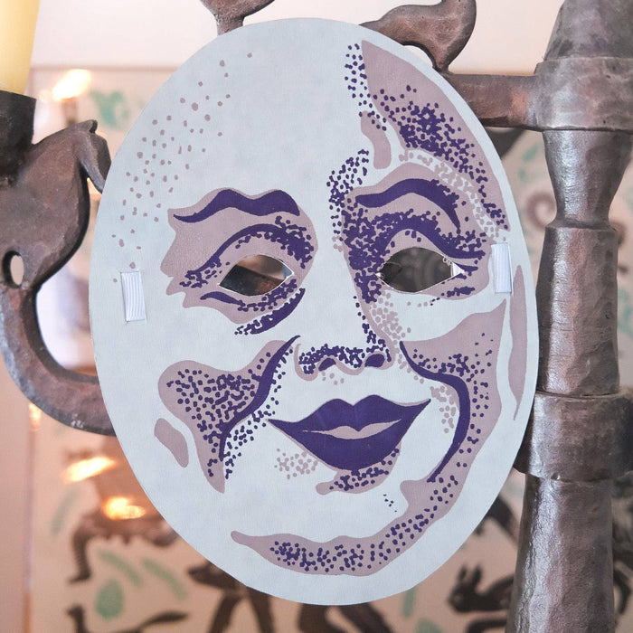 Decorative mask with purple accents on a decorative stand. Masks | East End Press | Shop Fodder