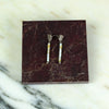 Pair of earrings on a maroon marble display stand against a marble background.  | Scarlett Cohen French | Shop Fodder
